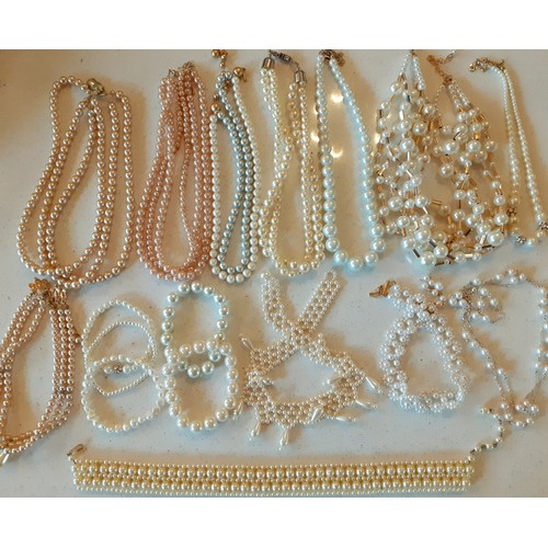 163 - A large quantity of faux pearl necklaces, chokers and bracelets in various styles and shades togethe... 