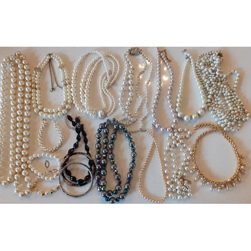 163 - A large quantity of faux pearl necklaces, chokers and bracelets in various styles and shades togethe... 