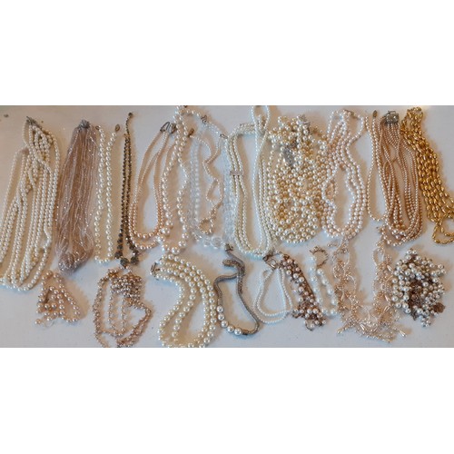 163 - A large quantity of faux pearl necklaces, chokers and bracelets in various styles and shades togethe... 