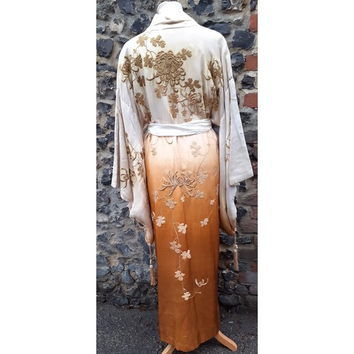 239 - An early 20th Century Japanese pale gold silk ground Kimono with sash belt and ombre effect to the m... 