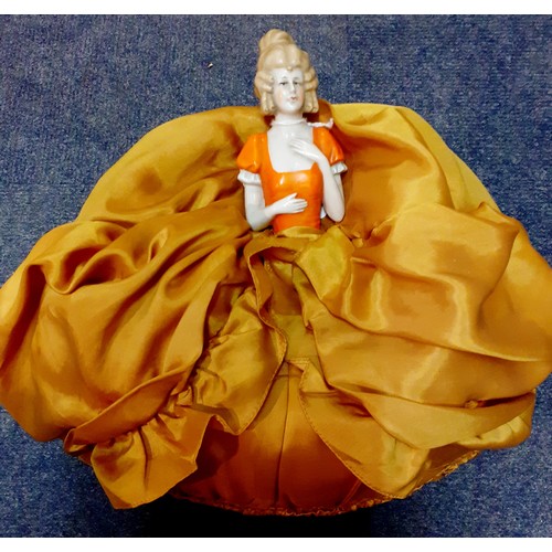 257 - A silk crinoline doll tea cosy having a porcelain body and gold coloured skirt, 39cm High together w... 