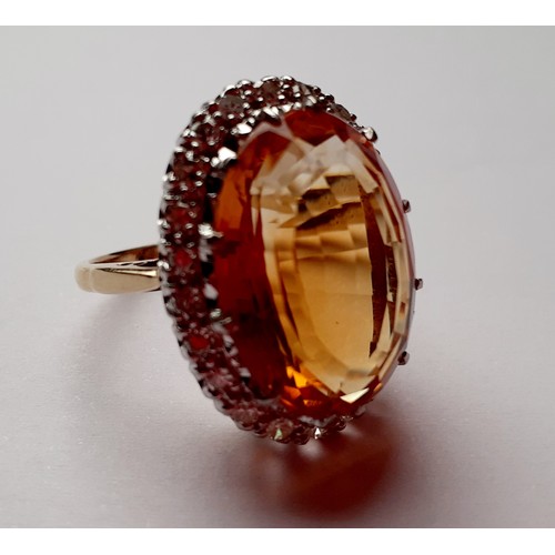 268 - A yellow metal ring having a large faceted oval citrine cabochon to the mount measuring 2cm surround... 