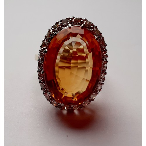 268 - A yellow metal ring having a large faceted oval citrine cabochon to the mount measuring 2cm surround... 