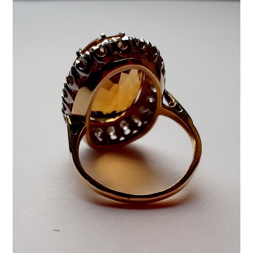 268 - A yellow metal ring having a large faceted oval citrine cabochon to the mount measuring 2cm surround... 