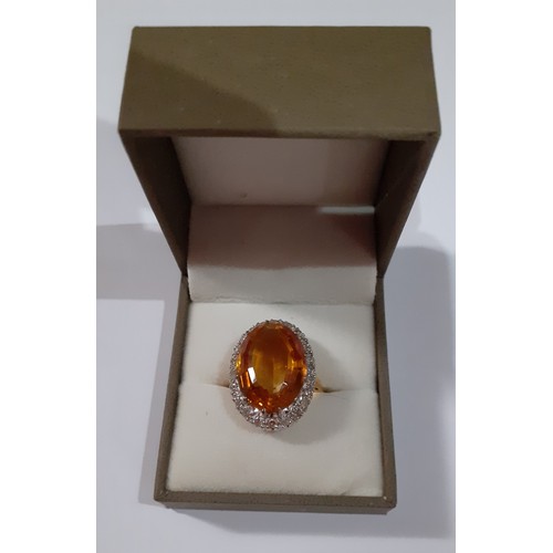 268 - A yellow metal ring having a large faceted oval citrine cabochon to the mount measuring 2cm surround... 