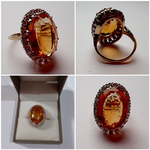 268 - A yellow metal ring having a large faceted oval citrine cabochon to the mount measuring 2cm surround... 