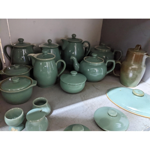 549 - A quantity of Denby green glazed table ware to include teapots, coffee pots, covered soup bowls and ... 