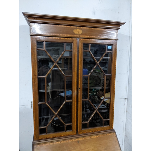 541 - An Edwardian Sheraton revival inlaid walnut and mahogany bureau bookcase, astragal glazed twin displ... 