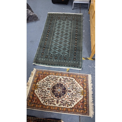 534 - Two hand woven rugs to include a Pakistani green ground rug with multi-guard borders and tasselled e... 