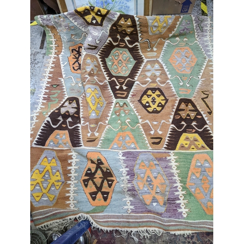 398 - A Kelim rug with geometric motifs in pastel colours 317cm x 147cm Location: RAM