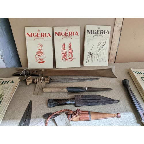 439 - A group of African daggers and a machete, some in leather sheaths, circa 1940 and a group of Nigeria... 