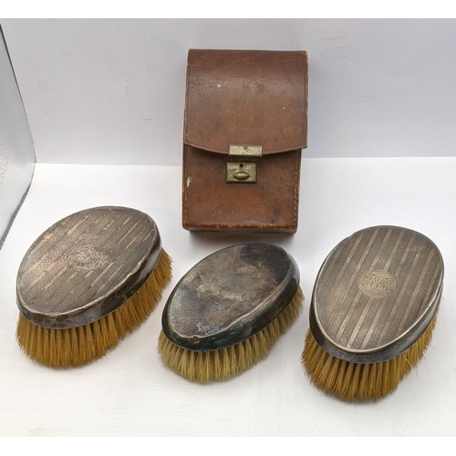 122 - Three silver dressing table brushes to include a pair having engine engraved detail and one in a bro... 