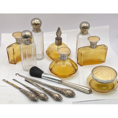 151 - Dressing table items to include brown glass bottles with engine turned lids, silver handled manicure... 