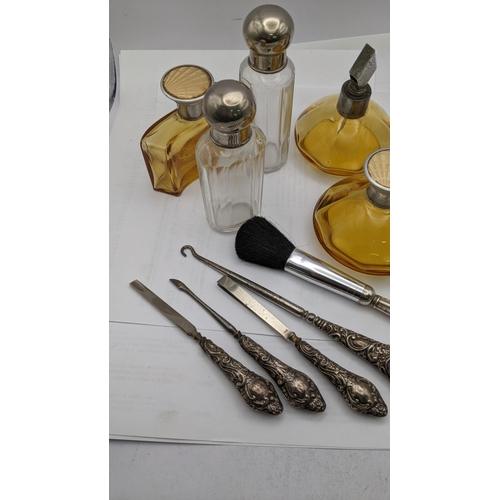 151 - Dressing table items to include brown glass bottles with engine turned lids, silver handled manicure... 