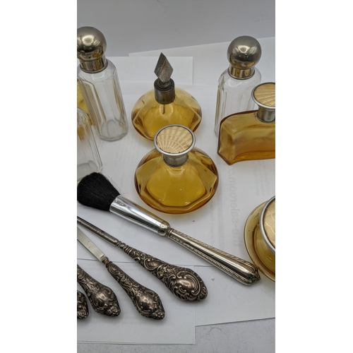 151 - Dressing table items to include brown glass bottles with engine turned lids, silver handled manicure... 