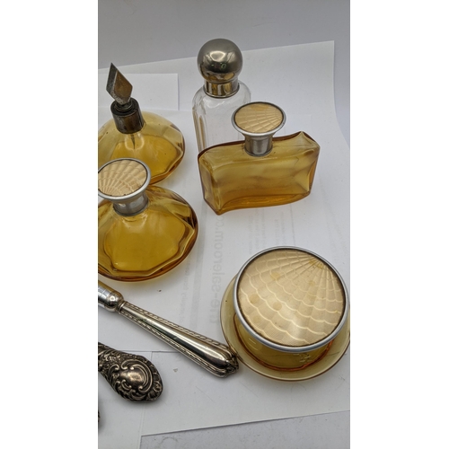 151 - Dressing table items to include brown glass bottles with engine turned lids, silver handled manicure... 