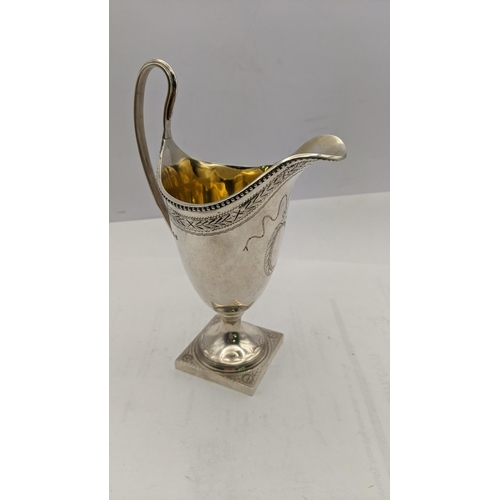 209 - A 20th century silver cream jug in the George III style with bright cut decoration 139.1g
Location: