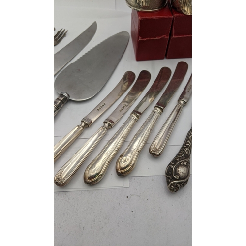 211 - Three silver napkin rings 55g silver handled knives, bread knife, button hook and cake knife
Locatio... 