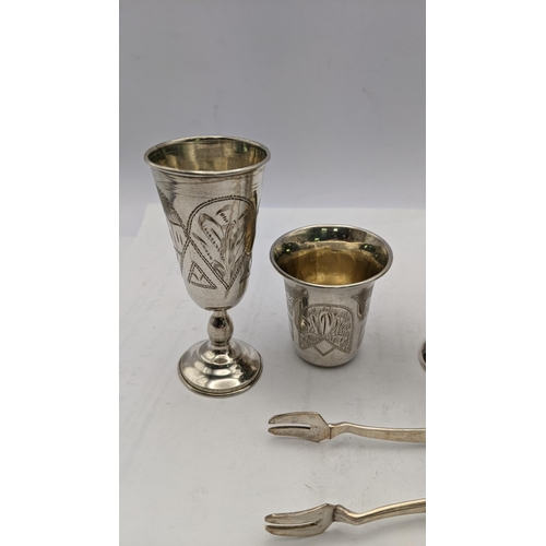 229 - White metal and sterling silver o include a pair of sugar tongs stamped 800, a pair of liquor glasse... 