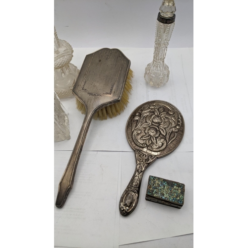 230 - Silver and white metal dressing table items to include a hair brush, an embossed mirror stamped 900,... 