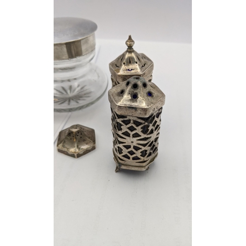 69 - A pair of silver pierced salt and pepper pots, together with a silver lidded dressing table pot, alo... 