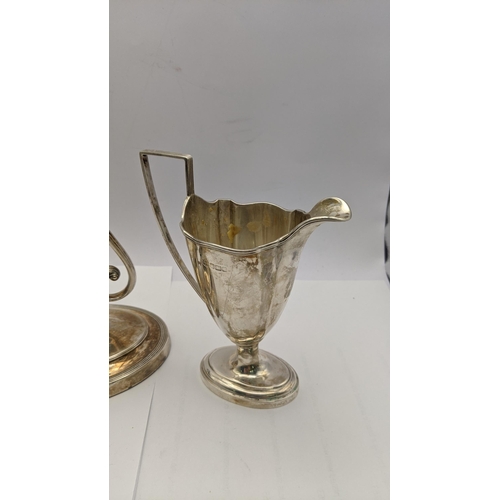 81 - A silver candle stick holder weighted hallmarked London 1902, together with a silver jug 113.1g
Loca... 