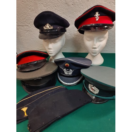 61 - A group of service hats to include a mid 20th Century British Military Army Officer's visor cap and ... 