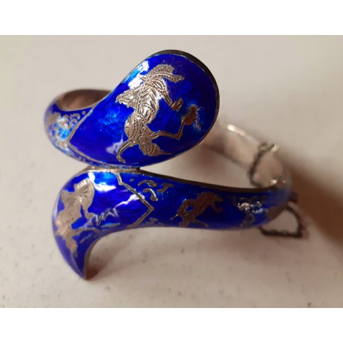 75 - A quantity of costume jewellery to include a Thai white metal and blue enamelled bangle in the form ... 