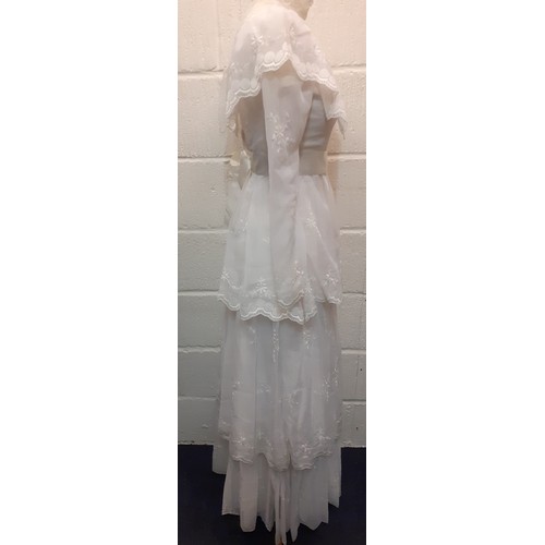 81 - A 1970's sheer white wedding dress UK size 10 with multilayered skirt having embroidered floral spra... 