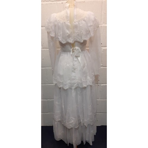 81 - A 1970's sheer white wedding dress UK size 10 with multilayered skirt having embroidered floral spra... 