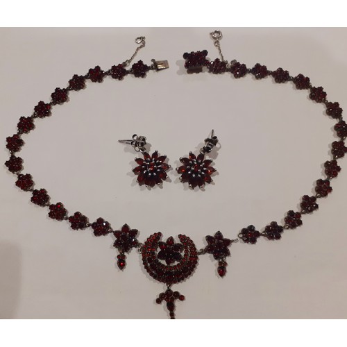 83 - An early 20th Century white metal and garnet coloured stone necklace having crescent moon and floral... 