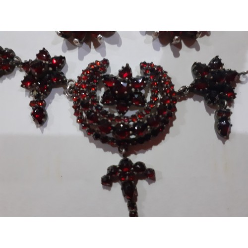 83 - An early 20th Century white metal and garnet coloured stone necklace having crescent moon and floral... 