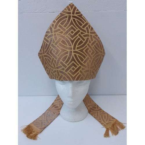 108 - An ecclesiastical mitre in a gold coloured fabric and tassels, 11