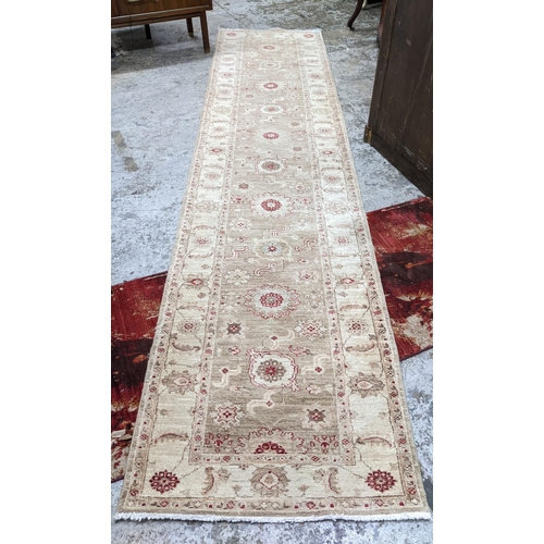 173 - A Persian hand woven runner, decorated with flower heads on a beige ground, triple guard borders, 35... 