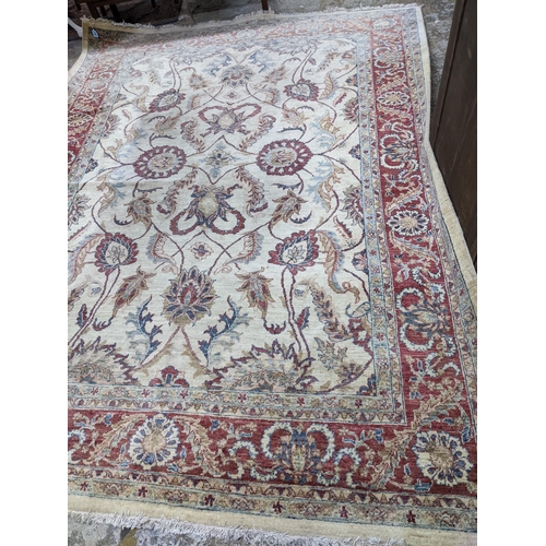 174 - A contemporary hand woven Afgan Zeigler rug, all over floral pattern on a sandy coloured ground, mul... 