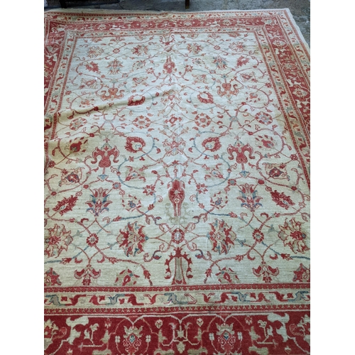 175 - A contemporary hand woven Afghan Zeigler rug, all over floral design in red and blue, on a sandy gro... 