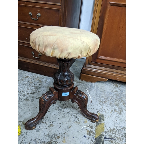 179 - Victorian mahogany swivel top music stool circular upholstered seat carved stone support on three kn... 