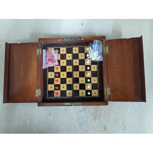 192 - A Victorian mahogany travelling chess set, the folding board with red and white plastic chess pieces... 