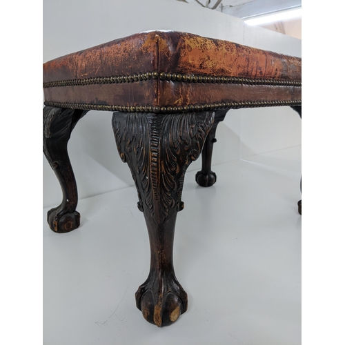 283 - Late Victorian/early 20th century carved mahogany stool, faded red upholstered set, on leap carved c... 