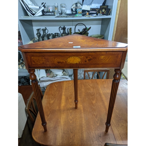 295 - An inlaid burr wood contemporary corner table with inlaid shell motif, on three turned and fluted le... 