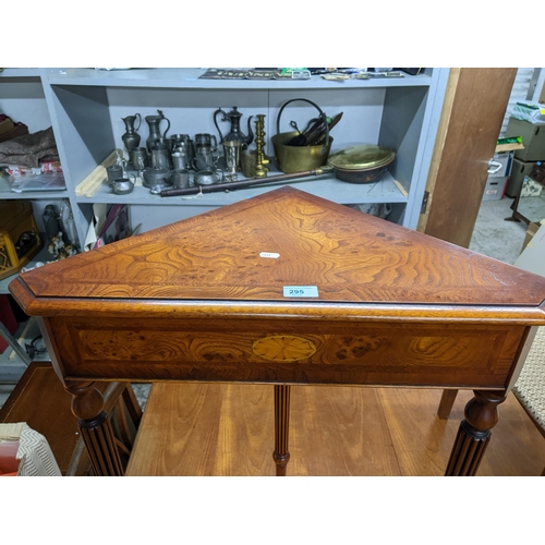 295 - An inlaid burr wood contemporary corner table with inlaid shell motif, on three turned and fluted le... 