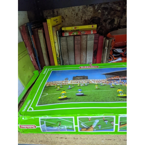 297 - A mixed lot of toys and books to include a boxed Subbuteo game, boxed die model motor bikes, tinplat... 