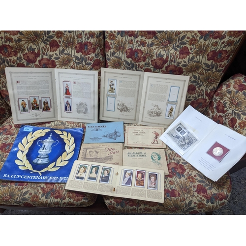 298 - A lot of cigarette cards mounted in albums, a Post office commemorative coins and stamp set to comme... 