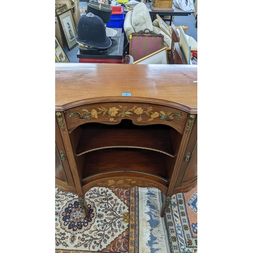 10 - An Edwardian mahogany cabinet having marquetry inlaid and gilt metal mounts, central drawer above op... 