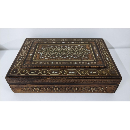 236 - An early 20th century Middle Eastern marquetry inlaid box having repeating motifs, mother of pearl i... 