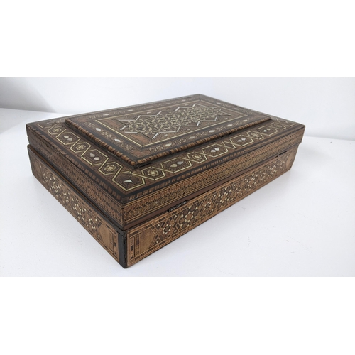 236 - An early 20th century Middle Eastern marquetry inlaid box having repeating motifs, mother of pearl i... 