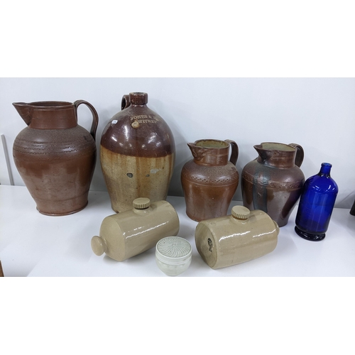 259 - A mixed lot to include a Jones & Rye Witney salt glazed flagon, two footwarmer, a Chiltern Hills wat... 