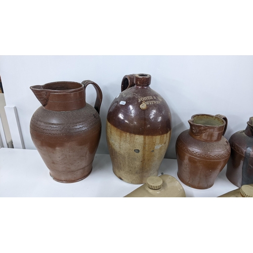 259 - A mixed lot to include a Jones & Rye Witney salt glazed flagon, two footwarmer, a Chiltern Hills wat... 