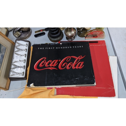 37 - A mixed lot to include a boxed set of name/menu holders, gold coloured Coca Cola bottles, framed pic... 