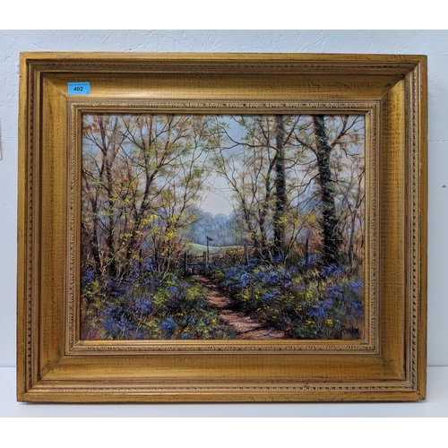 402 - Deborah Poynton oil on canvas, depicting a footpath through a woodland with bluebells, bears a signa... 